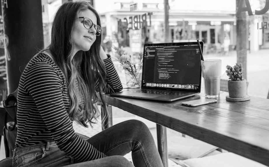 YOUNG ENGINEER WOMAN WORKING AT A COFFEE SHOP